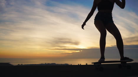 silhouette of a skateboarder against the sunset sky in slow motion steadicam shot