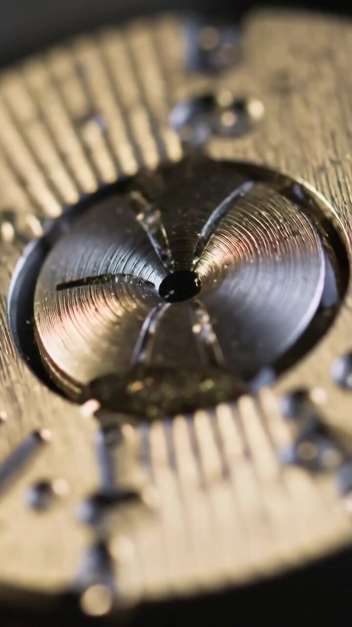 Vertical video: Shifting light causing camera focusing on tri-lobed part at bench revealing details