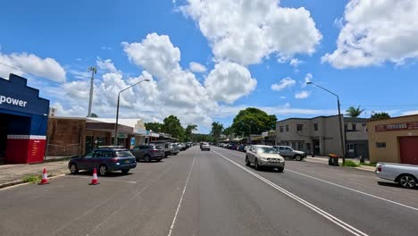 a bustling street in mullumbimby, nsw, with cars and shops under a bright blue sky