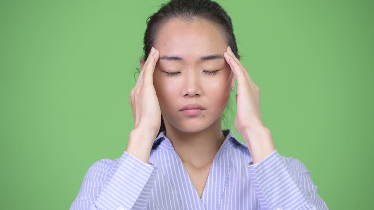 Young stressed Asian businesswoman having headache
