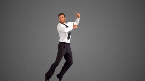 businessman jumping and giving thumbs up on grey background