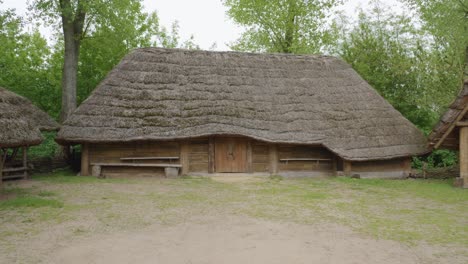 Replica-of-Ancient-Wooden-Slavic-House-with-a-skull---Biskupin,-Poland---tilt-up-shot