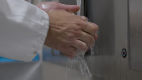 a man in a lab coat washing his hands