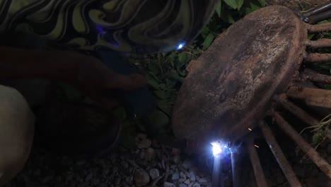 man in flame pattern helmet mig welding farm implement
