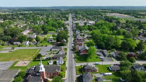 Drohne-Senkt-Sich-über-Einen-Weißen-Kirchturm-Und-Die-Mittelstraße-Einer-Kleinstadt-In-Den-USA