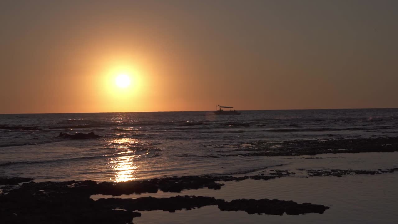 그림 같은 해가 지는 하늘 아래 파도 있는 바다에서 항해 하는 배