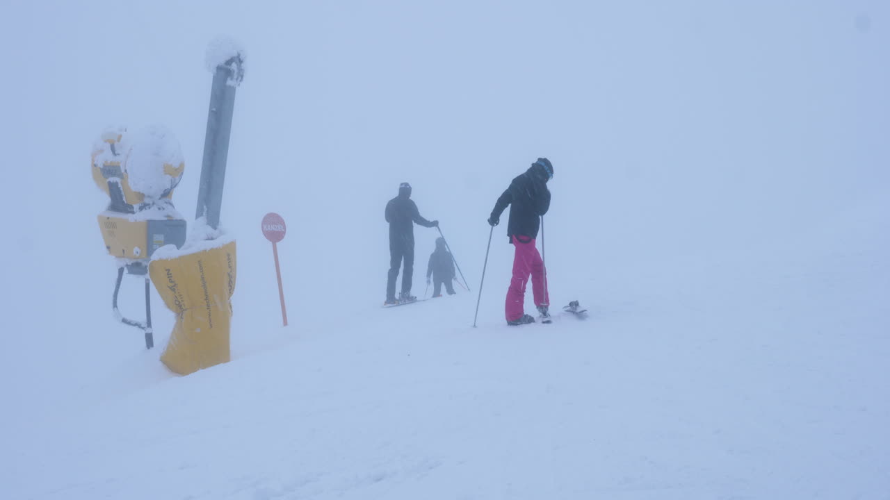 Skiers on a Foggy Mountain Slope