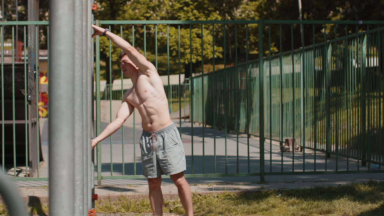 Athletic caucasian topless muscular man doing human flag exercise strength gymnastics elements