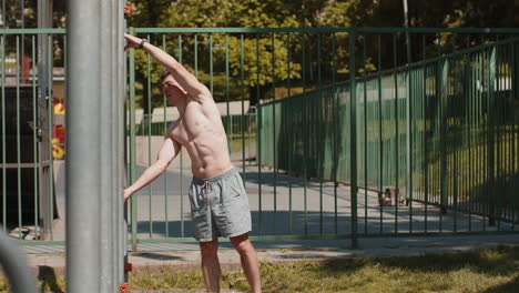 athletic caucasian topless muscular man doing human flag exercise strength gymnastics elements