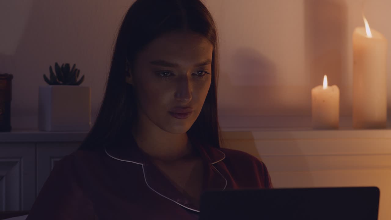 mujer trabajando en la computadora portátil en la cama por la noche