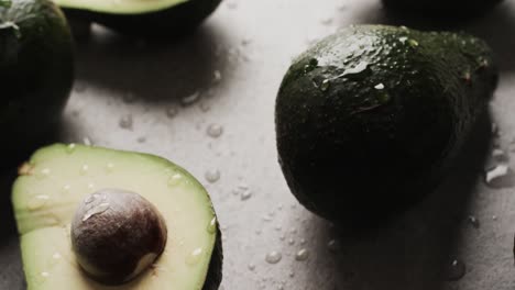 micro video of close up of avocados and water drops with copy space