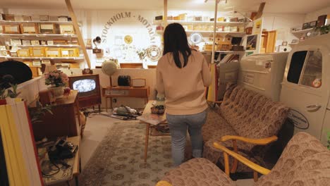 woman walking inside vintage living room at motala motor museum in sweden