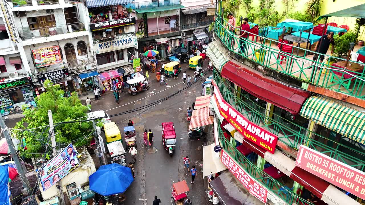 Aerial shot overhead a busy Bazaar Flea Market with locals driving past in New Delhi, India