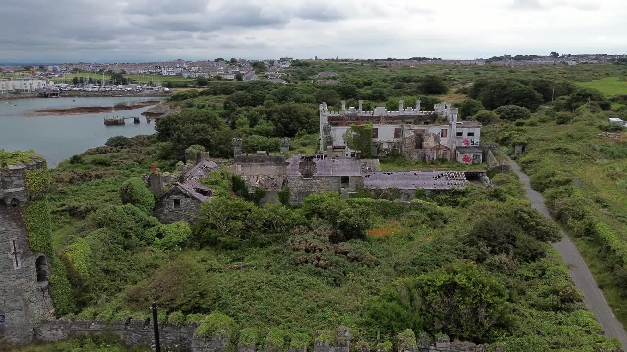 Remains of Soldiers point house castle aerial view circling overgrown North Wales coastal landmark