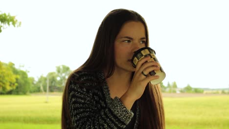 Lächelndes-Mädchen,-Das-Kaffee-In-Der-Natur-Trinkt