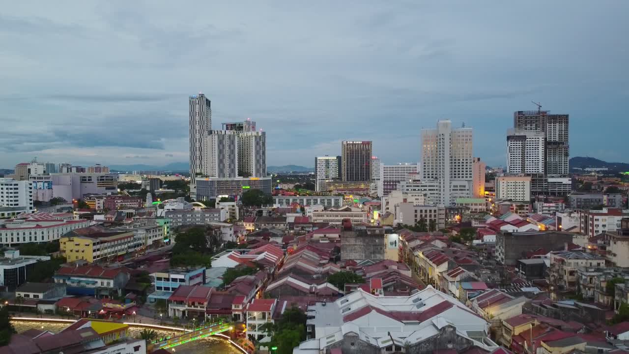 toma aérea descendente sobre la ciudad de melaka con el río malaca y el rascacielos por la noche