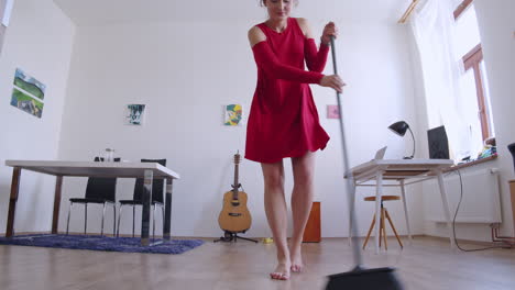 Happy-female-enjoying-housework,-cleaning-floor-and-dancing,-low-angle-slider-view