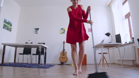 mujer feliz disfrutando de las tareas domésticas, limpiando el suelo y bailando, vista deslizante de ángulo bajo