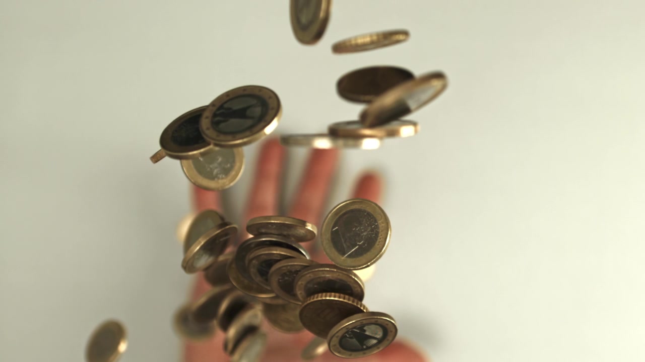 Euro Coins Falling in Slow Motion onto a Hand