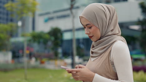 woman in hijab using her mobile phone outdoors