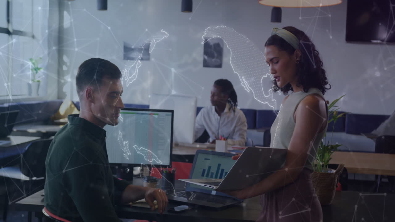 Diverse colleagues discussing data with world map animation overlay in modern office