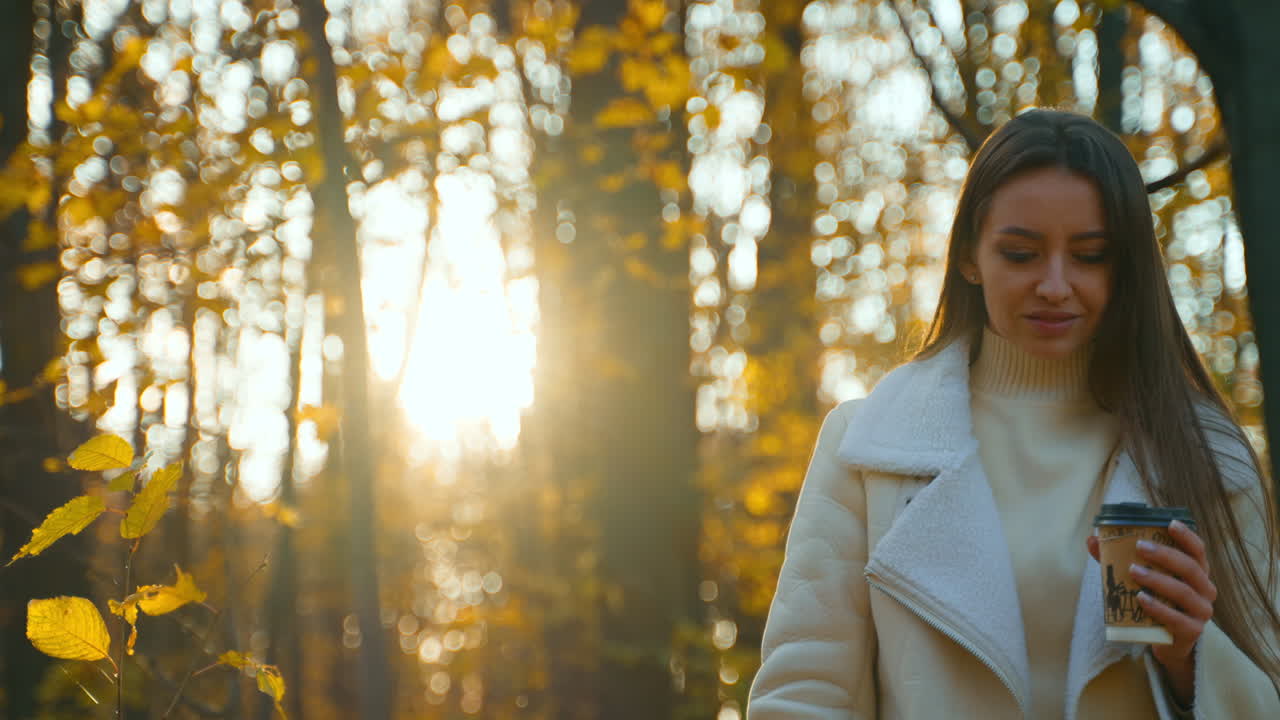 Woman with coffee in an autumn forest