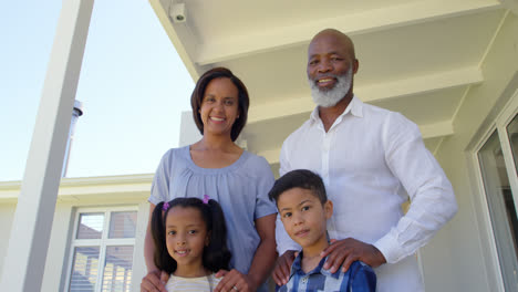 Low-angle-view-back-family-standing-on-porch-and-looking-at-camera-in-a-comfortable-home-4k