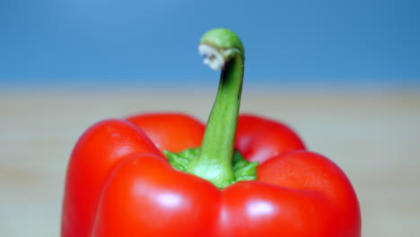 Red-Bell-Capsicum-On-A-Chopping-Board,-TILT-DOWN