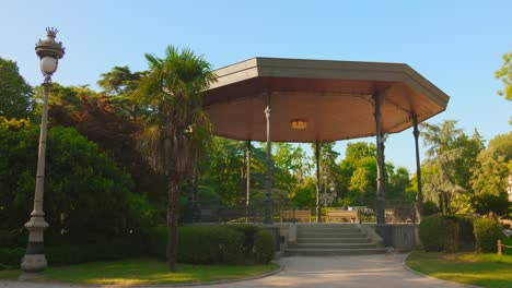 hexagonal gazebo with metal pillars in the middle of the grand rond park, surrounded by palm trees and trimmed bushes