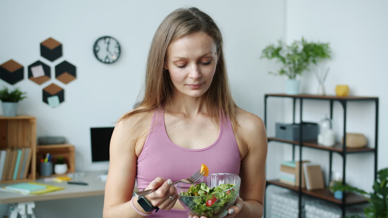 mujer comiendo ensalada en casa