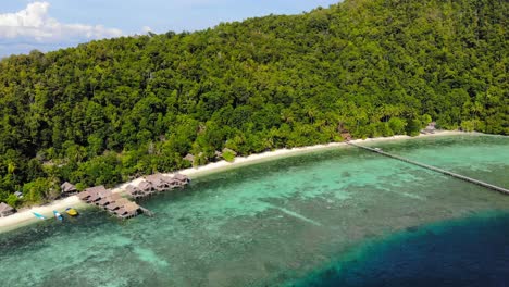 Beach-Bungalows-Over-The-Clear-Water-Of-Kri-Island-In-Raja-Ampat,-Indonesia