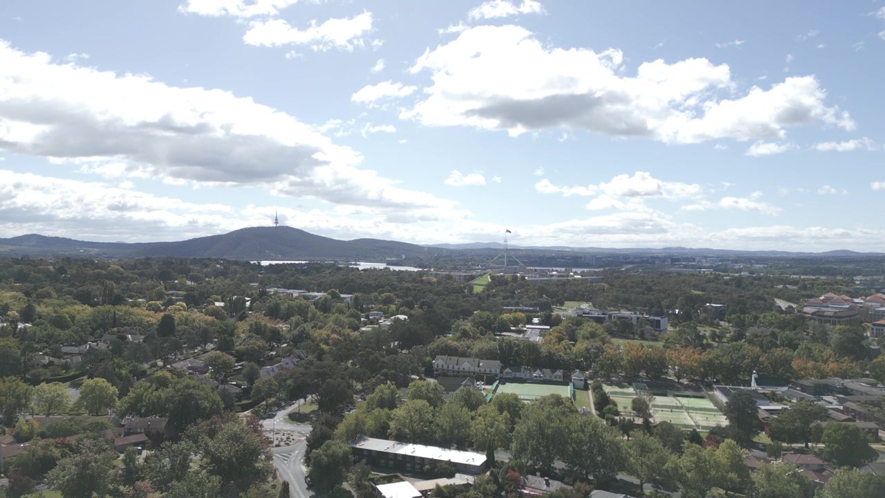 Canberra upward flying over the suburb with Capital Hill Parliament House and Telstra Tower in the background.