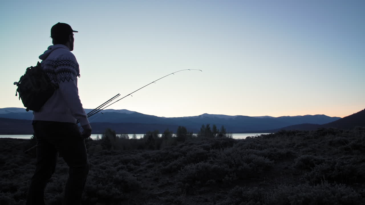 средний силуэтный снимок рыбака, входящего в кадр