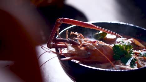 Sopa-De-Camarones-Humeante-Servida-En-Una-Olla-De-Barro-Tradicional,-Capturando-La-Esencia-De-La-Cocina-Tailandesa,-De-Cerca