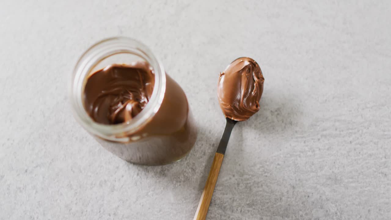Video ravvicinato di un vasetto di crema al cioccolato su sfondo bianco