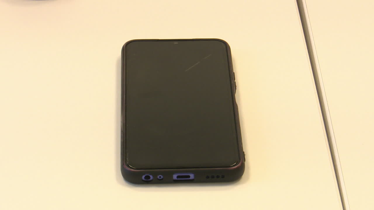 A dark smartphone on a white surface