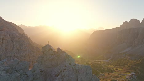 al amanecer sobre alta badia, una persona encuentra consuelo en el pináculo de piccola cir, asombrado por la naturaleza