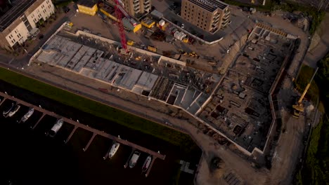 Top-down-backwards-reveal-movement-showing-the-construction-site-with-visible-blueprint-of-luxury-apartment-complex