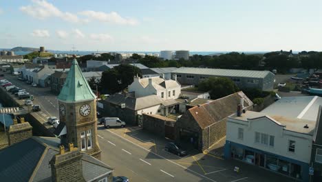 drone flight featuring clock tower st sampson’s harbour guernsey looking over southside and out to sea with herm and jethou in the distance on sunny day