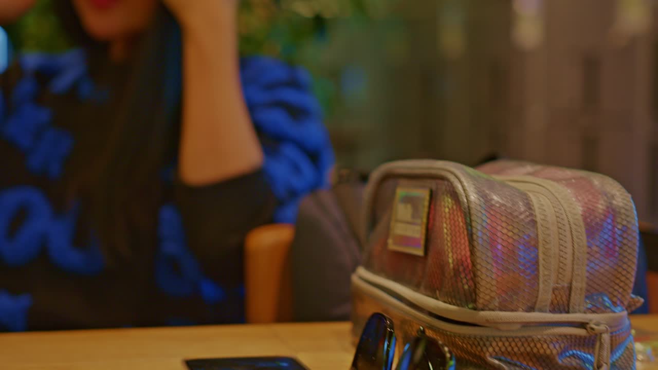 hermosa modelo de mujer asiática oriental femenina en un café restaurante con bolsa, gafas de sol y conversaciones por teléfono celular, chats, diálogo, conversación