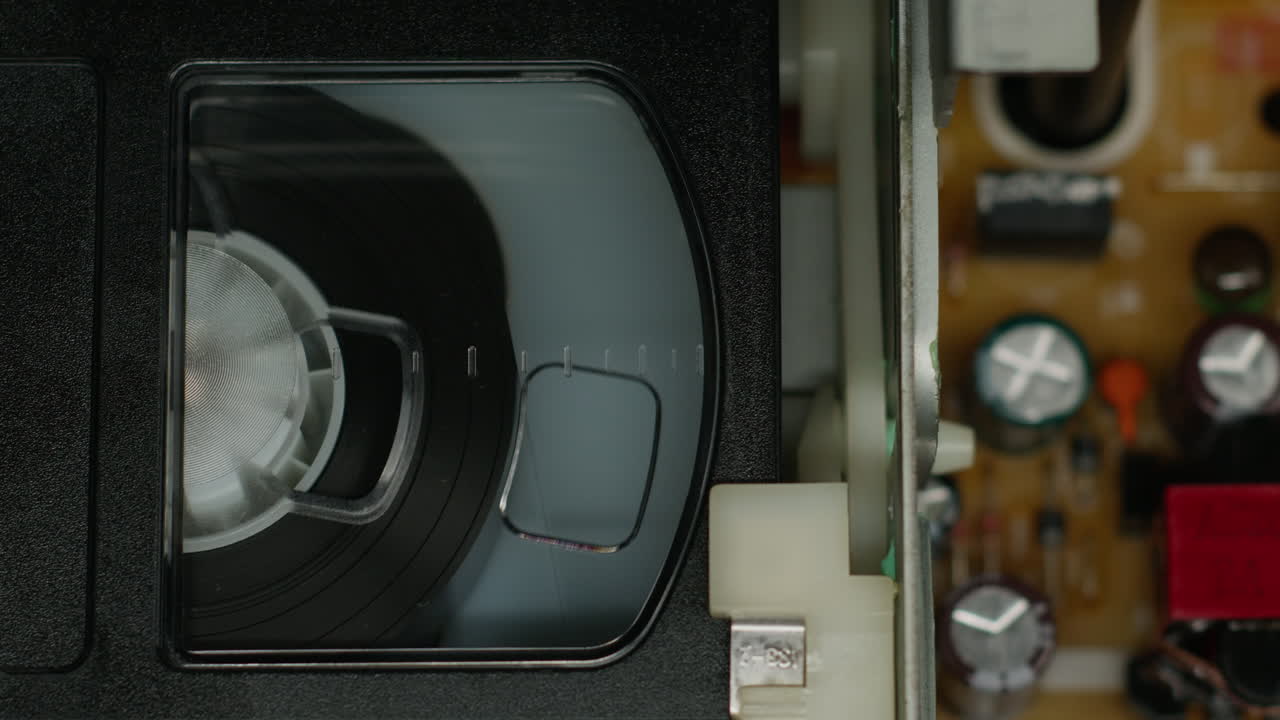 Old video recorder inside close-up, VHS. Retro player in neon blue light, vintage video cassette broadcasting, audio tape.