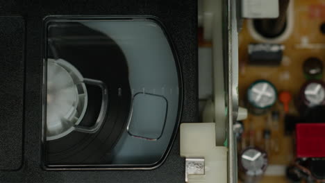 old video recorder inside close-up, vhs. retro player in neon blue light, vintage video cassette broadcasting, audio tape.
