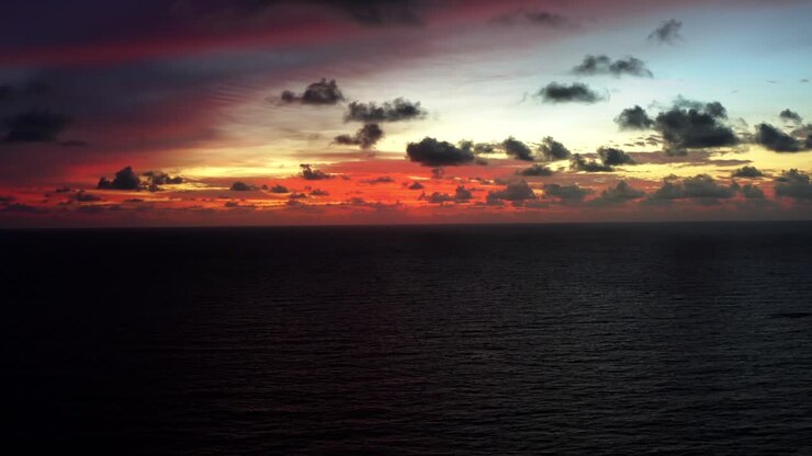 Aerial drone shot of a stunning red sunrise with the vast ocean below on a warm summer morning in Northern Brazil near Joao Pessoa