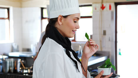 smiling chef smelling herbs in kitchen