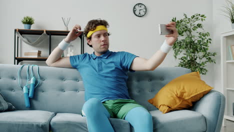 man taking selfie on couch in sportswear