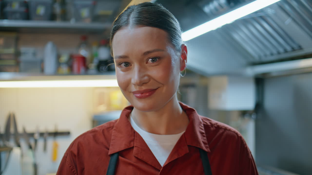 Happy woman chef smiling in restaurant kitchen closeup. Portrait professional