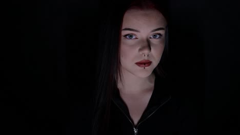 young woman posing while sitting handheld pan in front of a black background