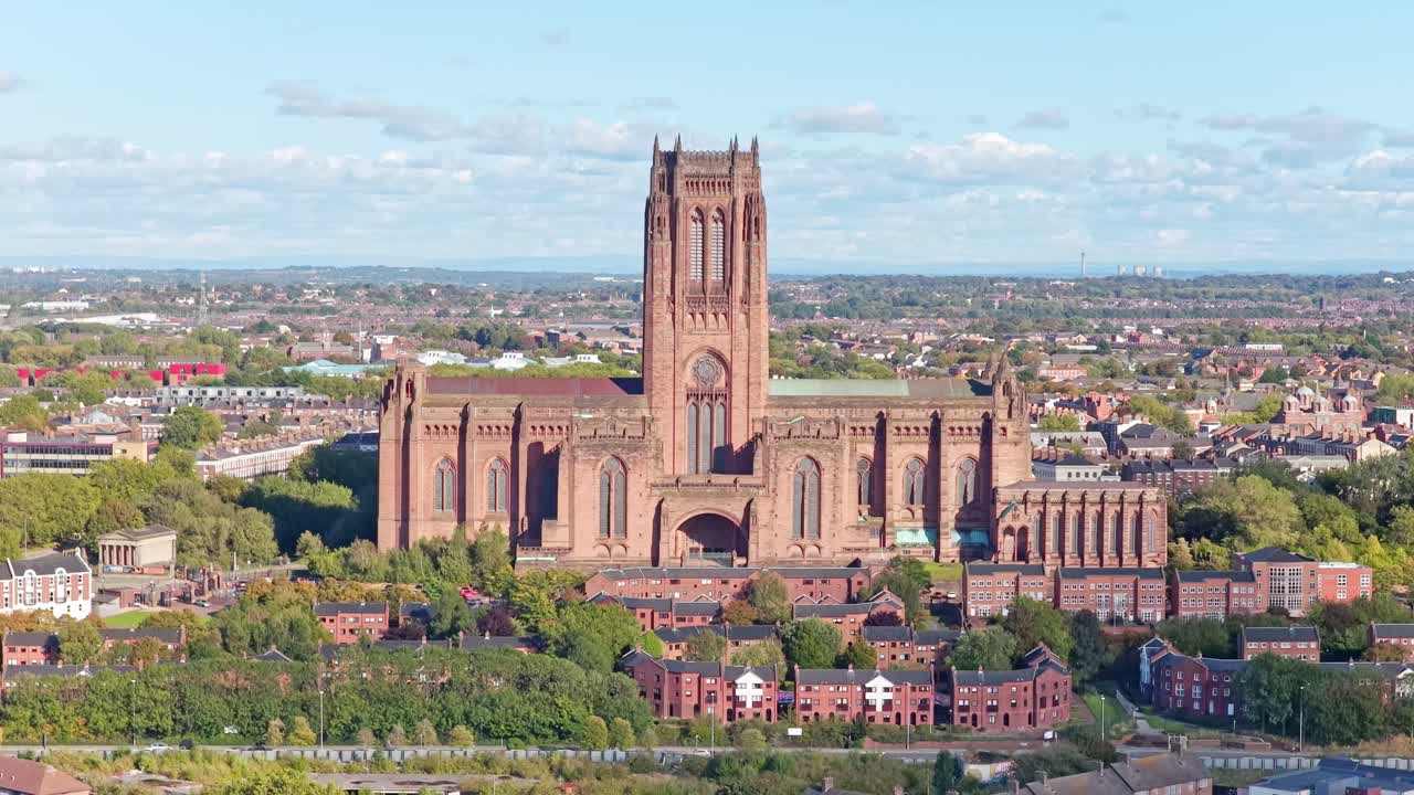 Drone footage of Liverpool Cathedral and the surrounding urban area on a sunny day. This cinematic clip captures the scale of the historic Anglican cathedral, nearby streets, residential housing