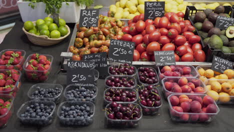 Counter-of-a-stall-in-the-Central-Market-of-Valencia,-Spain-with-a-variety-of-fresh-fruits-and-vegetables