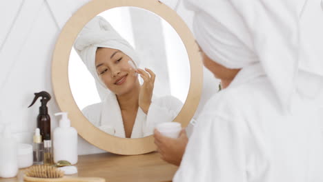 mujer aplicando crema facial